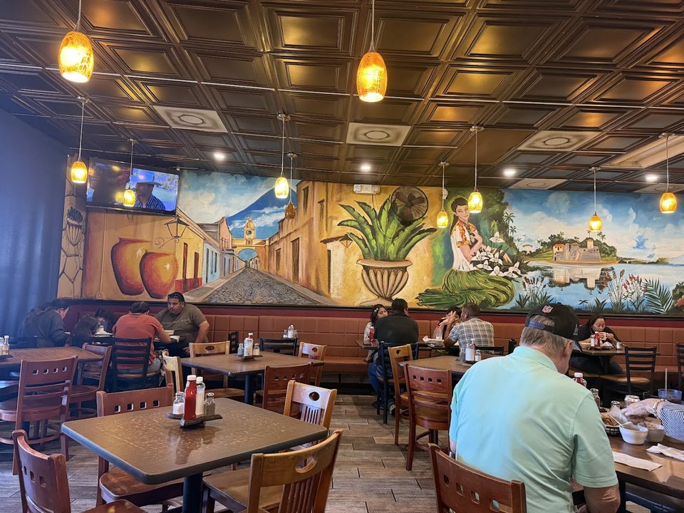 TVs above seating in a modest dining space.